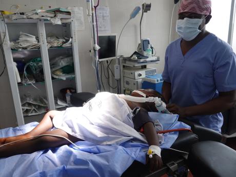 Dr. Sterman Toussaint Director for Clinical Services and Director for Medical Education with Partners in Health after a hernia operation  with a three years old boy 