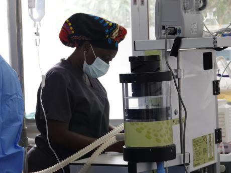 Partners in Health staff operating the anesthesia machine during surgery