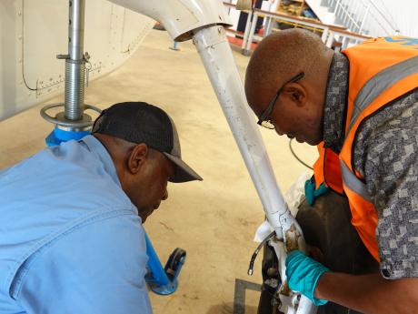 Gift Mposi and Peter Mburu working on MAF aircraft 